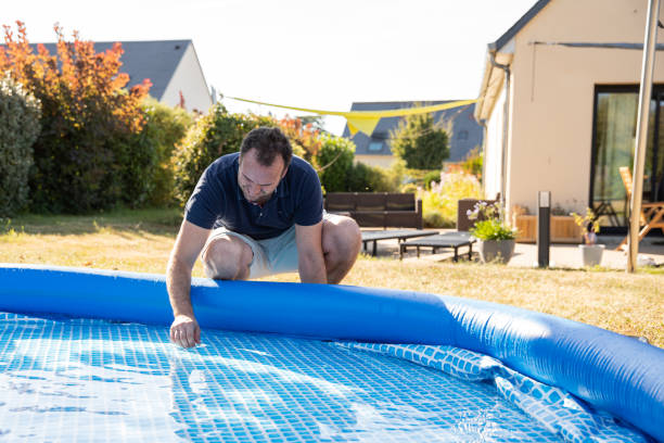istock Man working on inflatable pool, checking in, preparing it or removing for the summer season 2172879619
