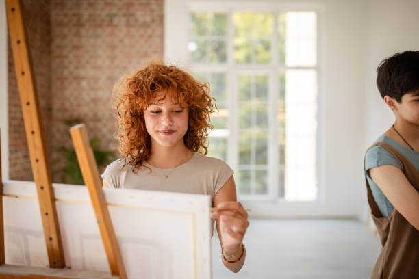 istock Artist painting on canvas in bright studio setting 2172885370
