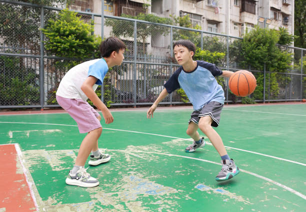 Asian boy playing basketball on a basketball court