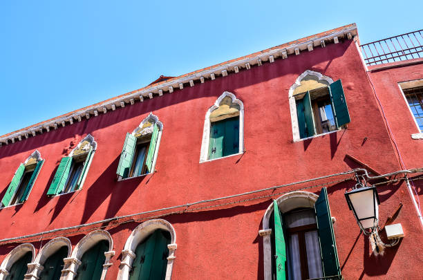 Old town of Venice with historic house with eu flag and Italian flag on a blue cloudy summer day. Photo taken August 6th, 2023, Venice, Italy.