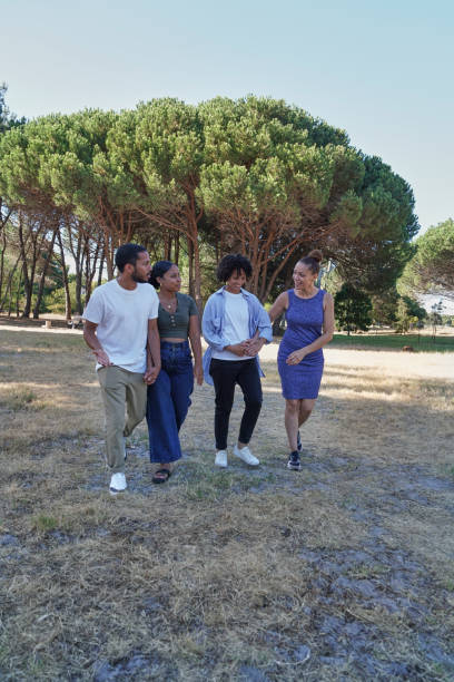 istock Friends walking in grassy field 2172895304