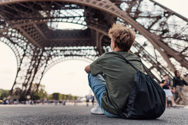 istock Teenage boy sitting under the Eiffel Tower 2172896181