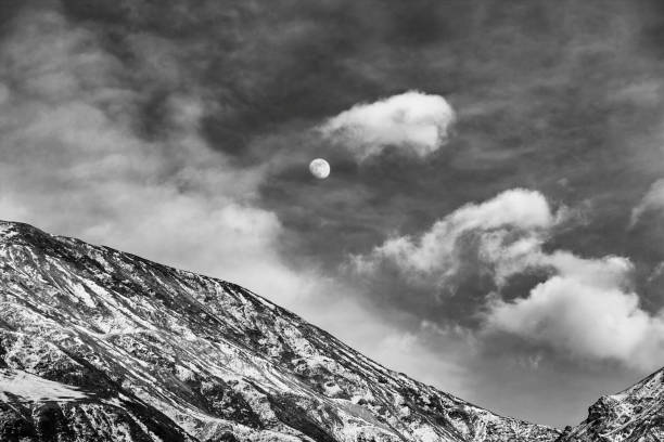 A landscape with snow-covered mountains in black and white