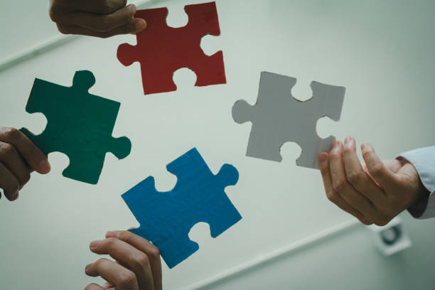 istock successful business team collaborates to solve challenges, symbolized by completing the final piece of a jigsaw puzzle, representing unity, strategy, and shared achievement. 2172899104