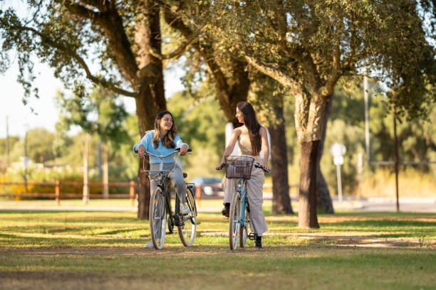 istock Women riding bicycles and talking in a public park 2172901353