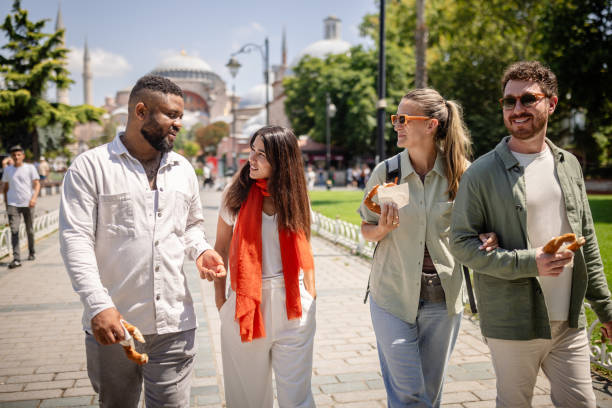 istock Friends stroll with snacks in historic green park. 2172904662