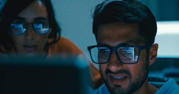 istock Closeup of Tech team professionals collaborate discuss software development strategies late night in modern office. Software developer, artificial intelligence and programming. 2172905767