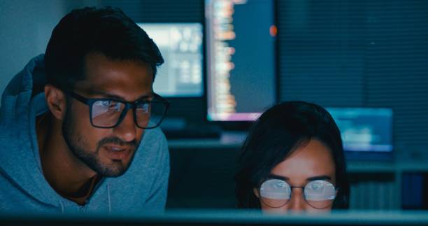 istock Tech team professionals collaborate discuss software development strategies late night in modern office. Software developer, artificial intelligence and programming. 2172905776