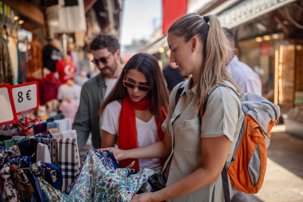 istock Women shopping for patterned fabrics at market 2172908294