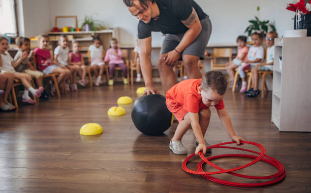 istock Boy collecting hula hoops during fun classroom game 2172911972
