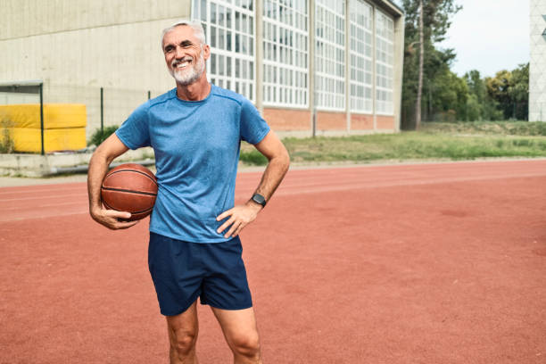istock Mature Man Holding a Ball and Smiling Looking At Camera 2172916949