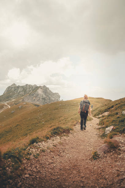 istock Young woman hikes mountain pathway 2172921276