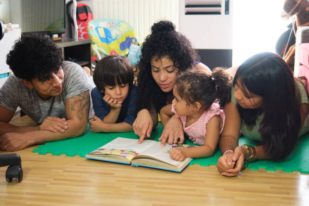 istock Hispanic family spending time together reading a book at home 2172925082