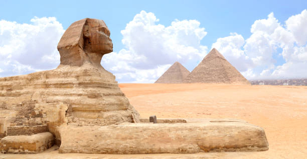 istock Famous Great Sphinx and pyramids of Chephren and Cheops, Cairo, Egypt. Great Pyramids and ancient statue of Sphinx, mythical creature with head of man and body of lion, Giza complex (Giza Necropolis) 2172926346