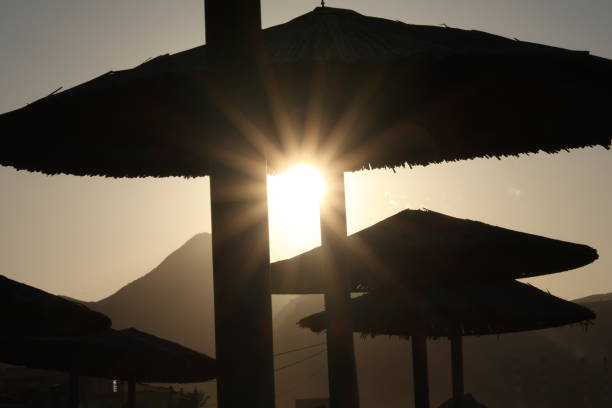 Sun setting behind the mountains at the beach in Crete, Greece