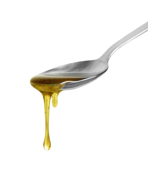 istock Olive oil flows from a spoon close up isolated on a white background 2172930685