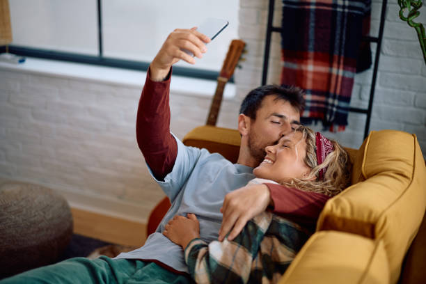 istock Affectionate couple taking selfie while relaxing at home. 2172932758