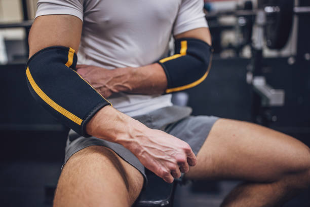 istock Person sitting on gym bench wearing elbow support pads. 2172937528
