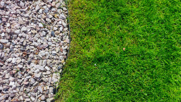 istock A vibrant and contrasting design featuring lush green grass next to a border of decorative pebbles. Ideal for landscaping, gardening, or outdoor themes. 2172937708
