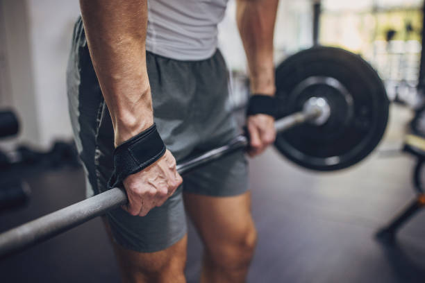 istock Man holding barbell with wrist support at gym. 2172941639