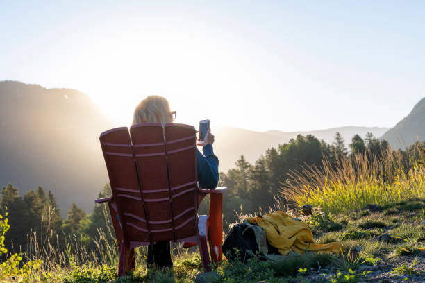 istock Mature hiker uses mobile phone in mountain meadow 2172943625