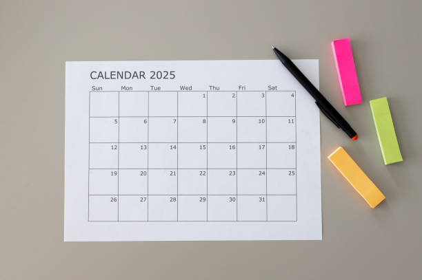 istock Blank calendar with 2025 writing and a pen and colorful note stickers on table. Space for text 2172944679