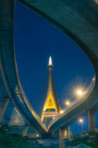 image captures stunning architecture of bridge at night, showcasing its illuminated structure and surrounding urban landscape. vibrant lights create captivating atmosphere