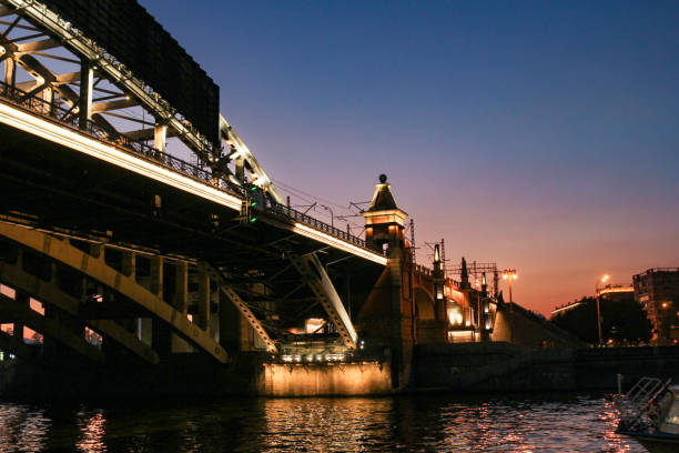 Moscow, Russia - 26, August, 2024.Water excursion on a boat along the evening Moscow River.Artistic illumination of the Andreevsky Bridge.