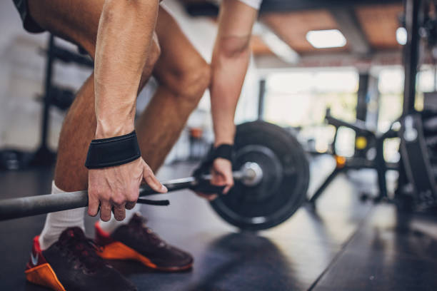 istock Gym-goer lifting barbell with visible focus and effort 2172946573