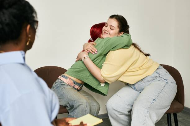 istock People Hugging During Group Therapy Session in Cozy Room 2172954697