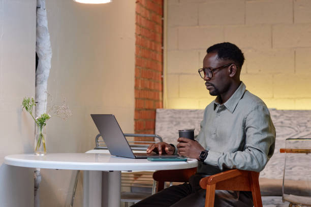 istock Man Wearing Glasses Sitting at Desk Using Laptop 2172956254