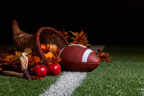 istock A cornucopia with a football on a grass field with stripe and dark background 2172956493