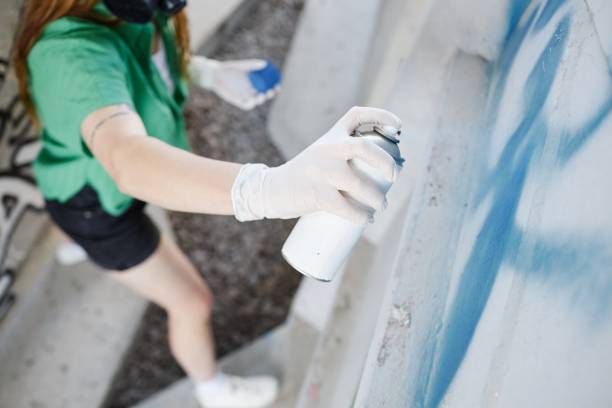 Beautiful girl about to draw a graffiti on a wall with copyspace