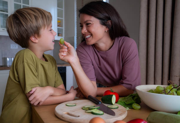 istock happy mom feeds her son with grapes 2172980854