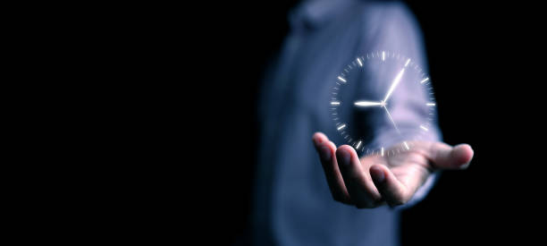 istock Time management concept. Man with clock in his hand paying attention on managing and planning his life, business, work for productivity using technology 2172983106