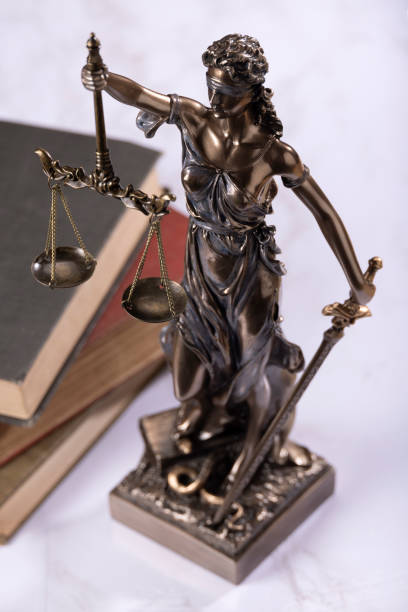 istock Lady Justice with books in the background on white marble 2172991382