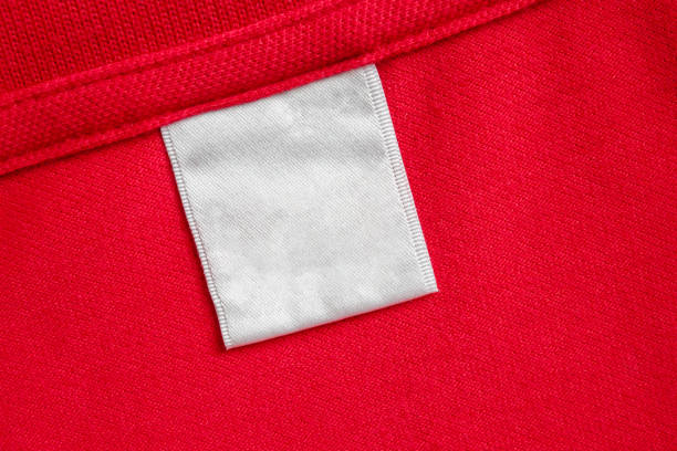 istock Blank white laundry care clothes label on red shirt fabric texture background 2172998063
