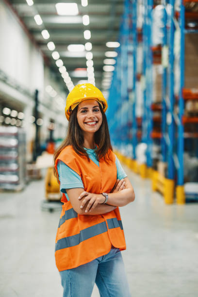 istock Female employee standing in bright warehouse with supportive smile. 2172999918