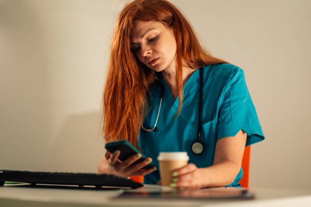 istock Doctor having coffee while checking messages on a smartphone. 2172999961