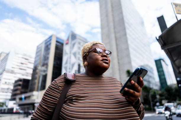 Young woman using mobile phone and walking through the city