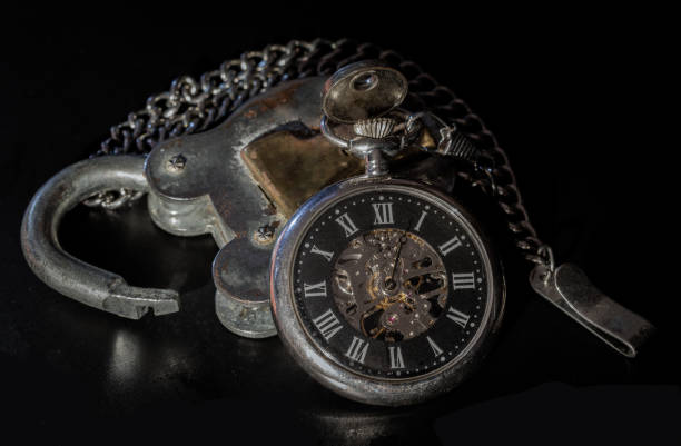 istock A retro pocket watch on Old vintage iron padlock on dark background. 2173004545