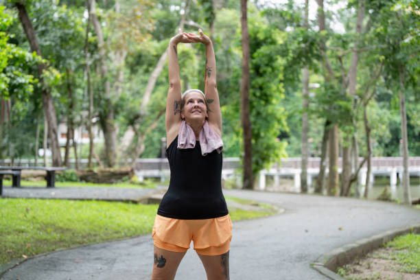 istock Elderly woman performing full body stretch in park 2173022817