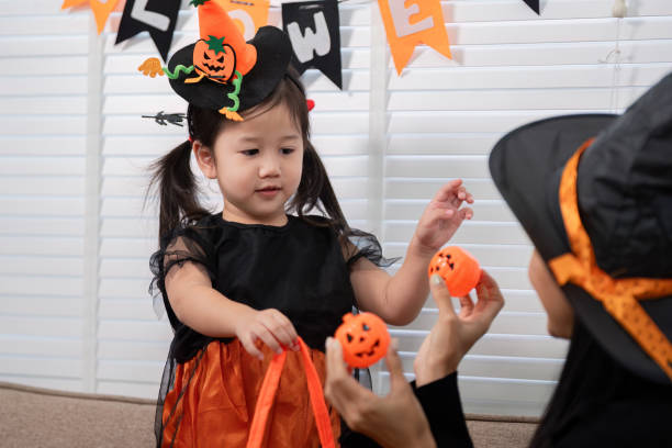 istock Playful Child and Parent Halloween Pumpkin Activity 2173027390