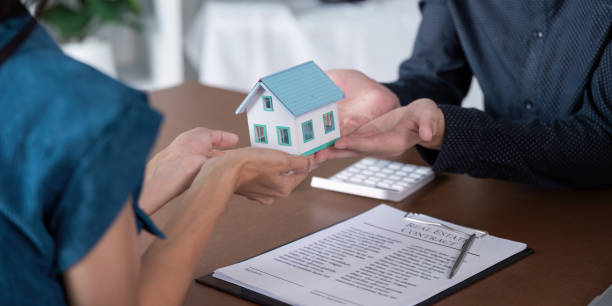 istock Real Estate Agent Facilitating Home Purchase Agreement with Clients 2173029026