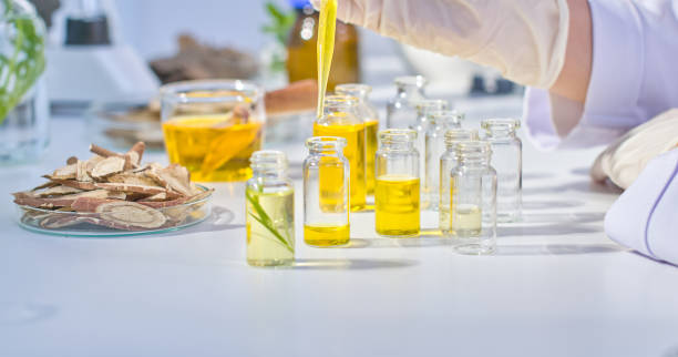 istock Model photo for oriental medicine experiments with a frontal angle showing a scientist dropping solution into a mini glass bottle, surrounded by herbs and professional equipment on the table. 2173033412