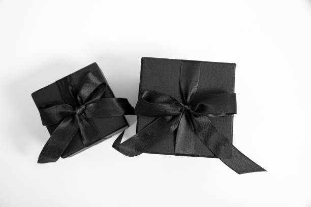 istock Black Friday Sale. Black gift boxes with ribbon bow isolated on white, top view 2173046636