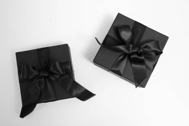 Black Friday Sale. Black gift boxes with ribbon bow isolated on white, top view