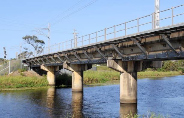 istock Railway bridge spanning over a river of water under a blue sky 2173050361