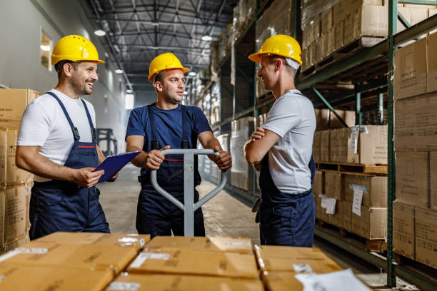 istock Team of happy workers talking in distribution warehouse. 2173051426