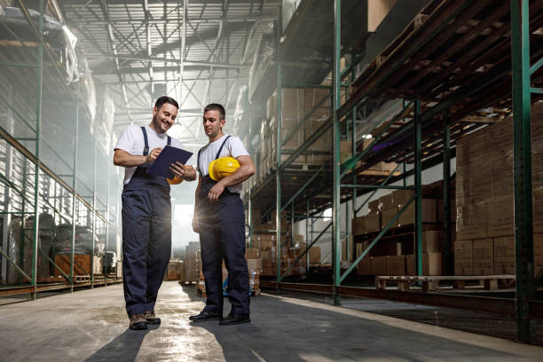 istock Happy manual workers reading checklist in a distribution warehouse. 2173051439